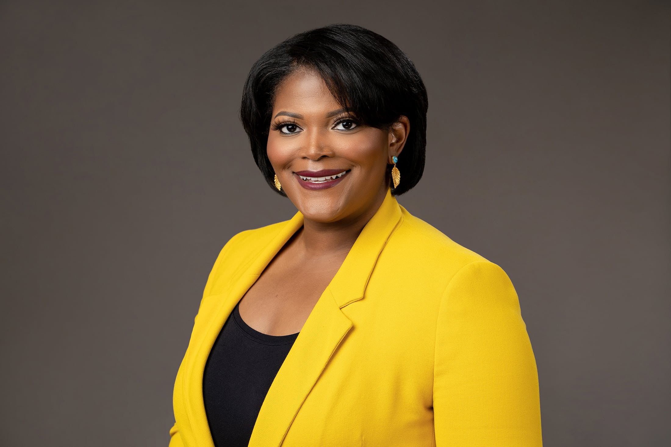 a woman in a yellow jacket posing for a photo.