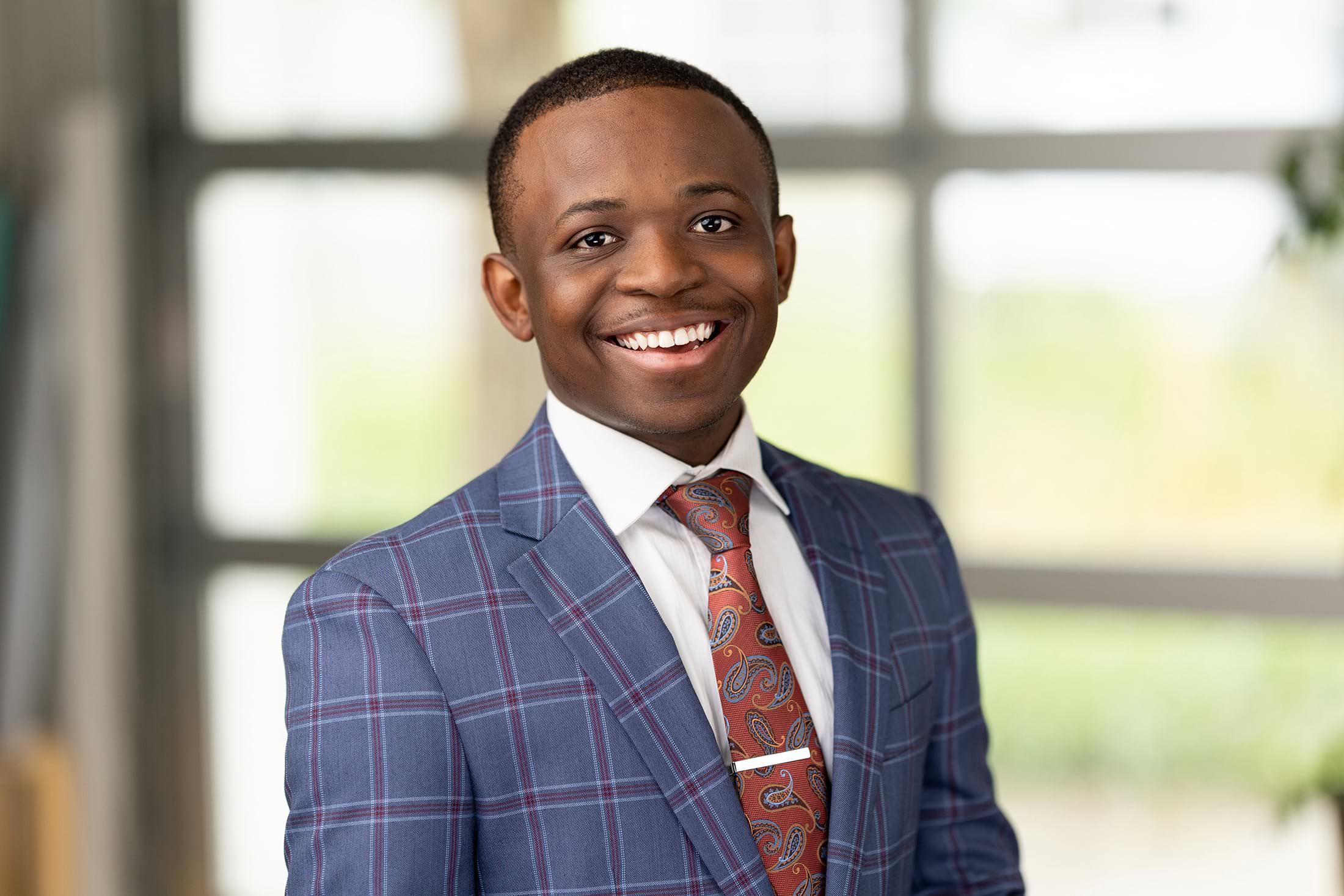 a smiling young man in a suit and tie.