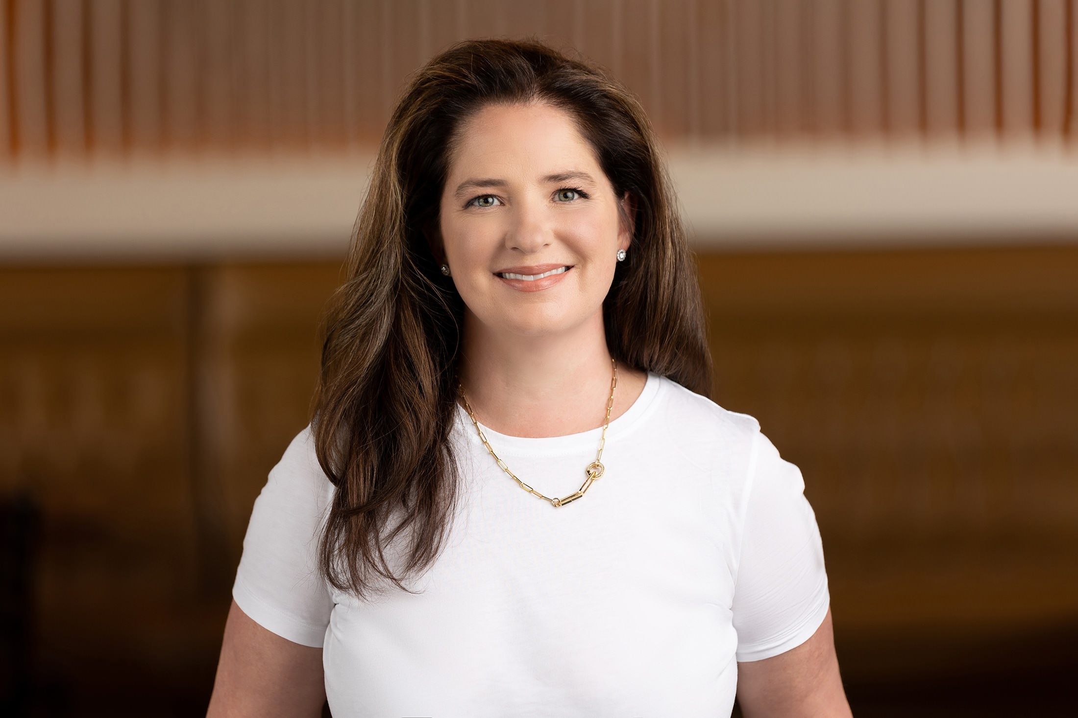 a woman in a white shirt smiling for the camera.