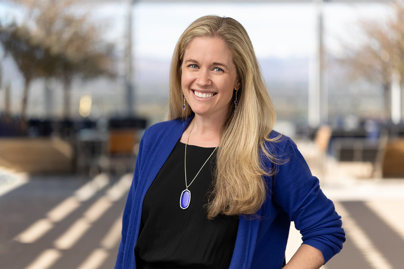 A woman in a blue cardigan showcases how headshots help with growth.