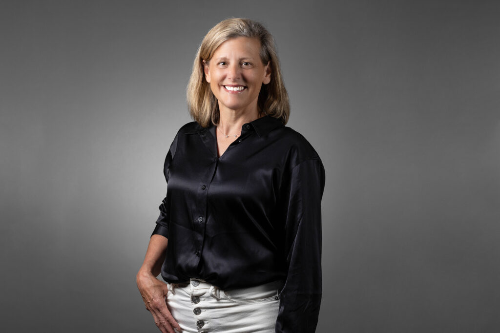 Professional woman in a solid dark-colored shirts exuding confidence.