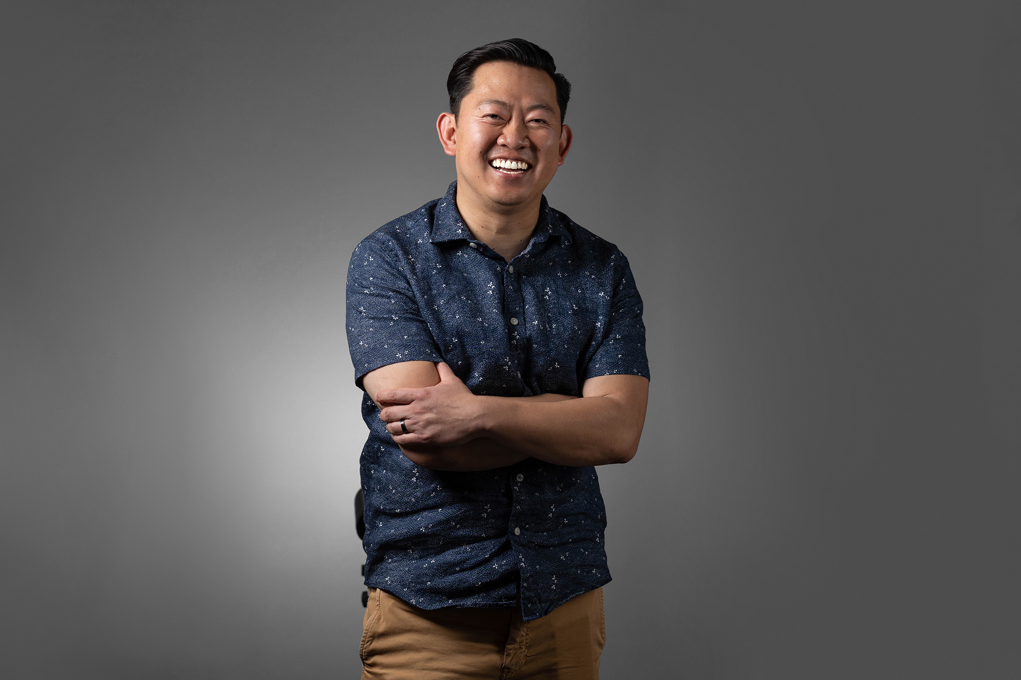 A man in a blue shirt with his arms crossed for corporate headshots.