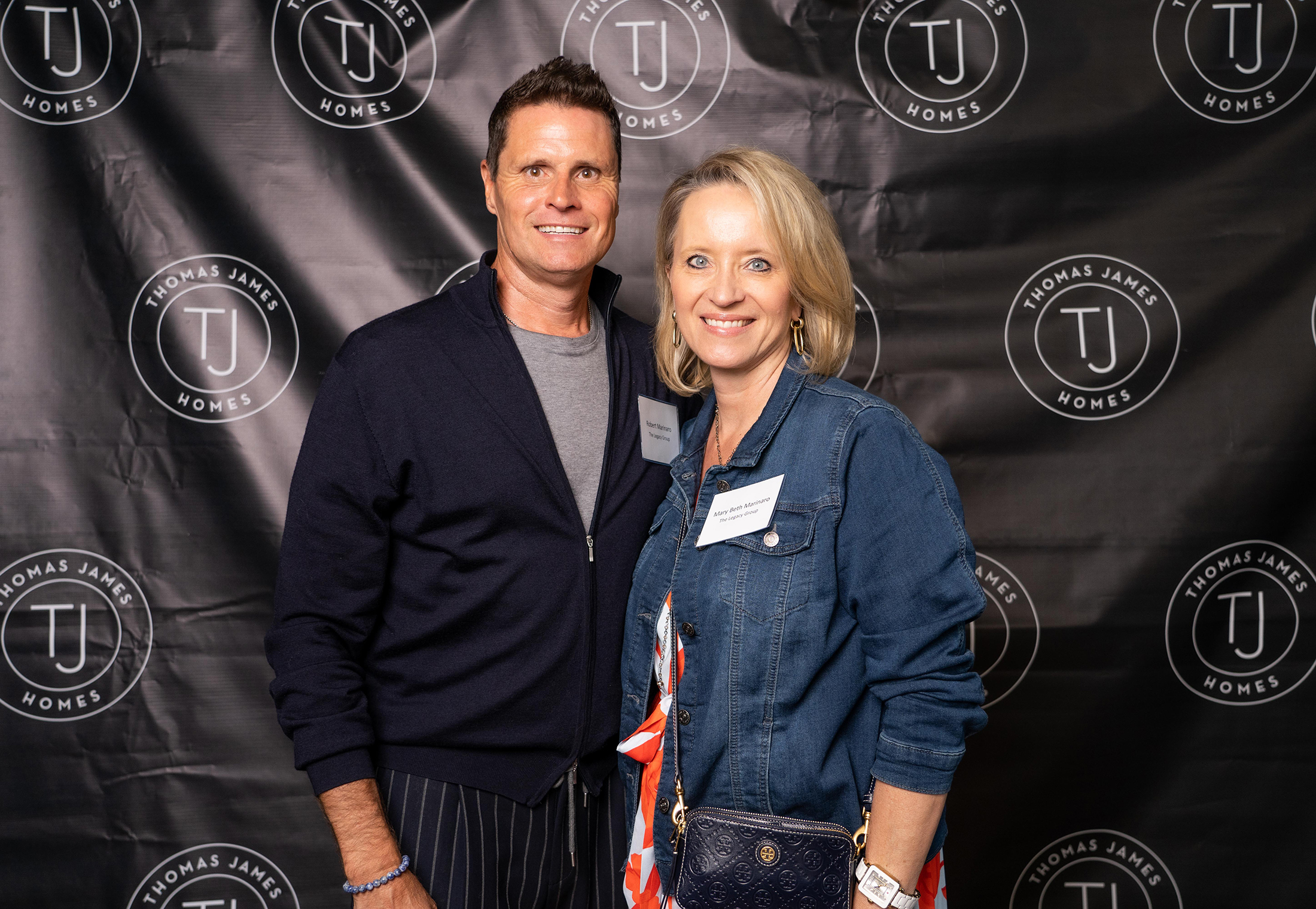 A man and woman posing for holiday party photos at an event.