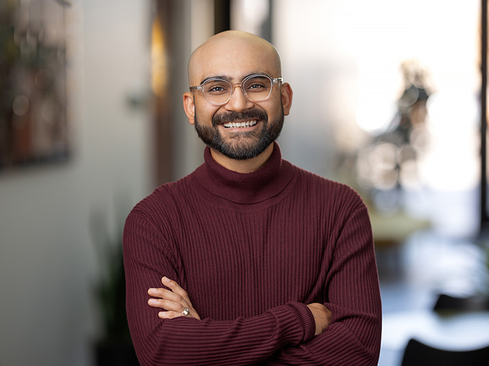 An individual wearing glasses and a burgundy sweater.