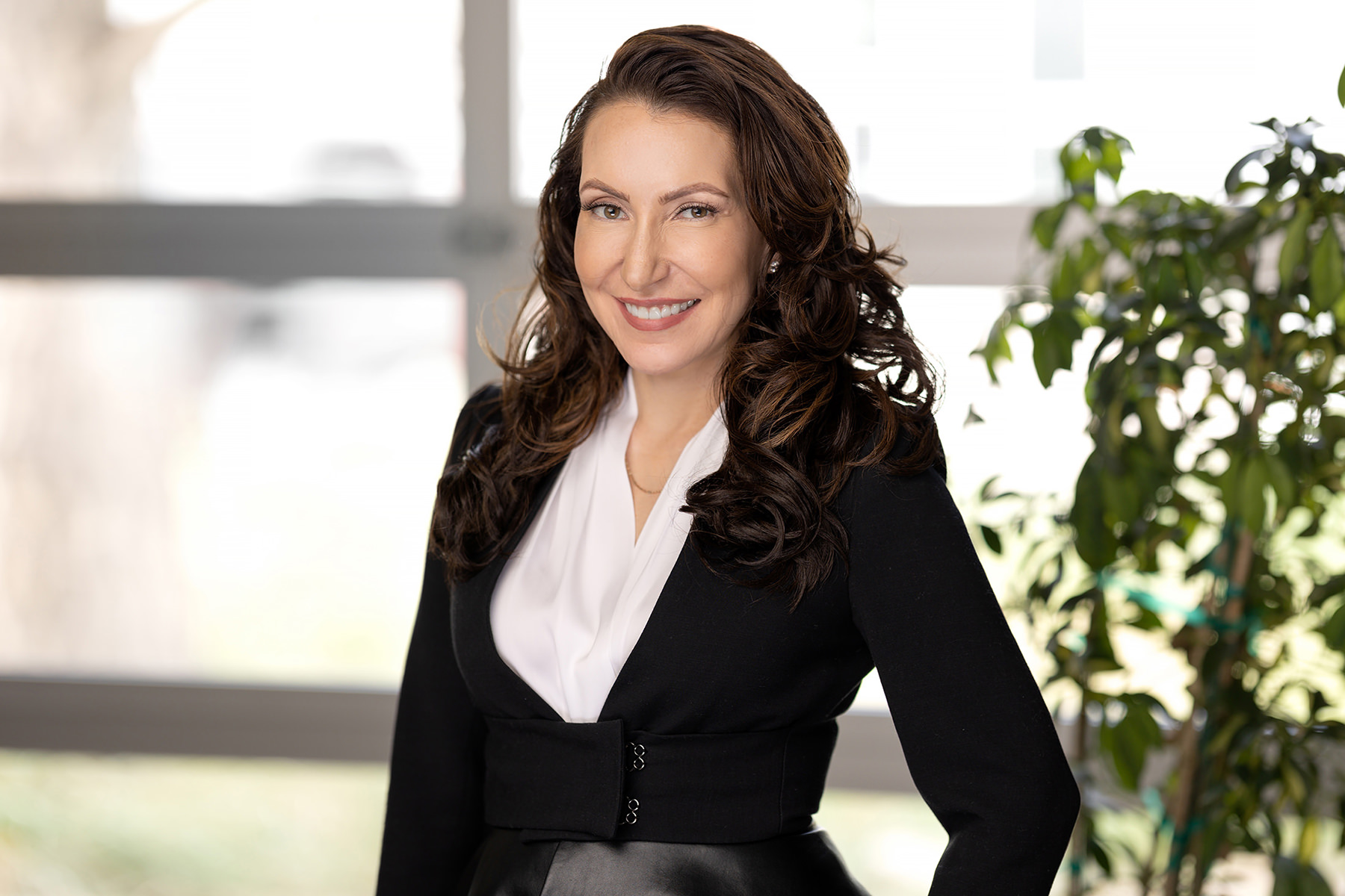 Professional woman posing for a business portrait in an office setting for her Denver headshots.