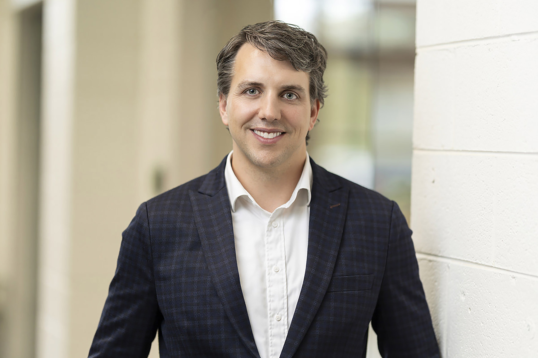 Professional man smiling in Denver business suit headshots.