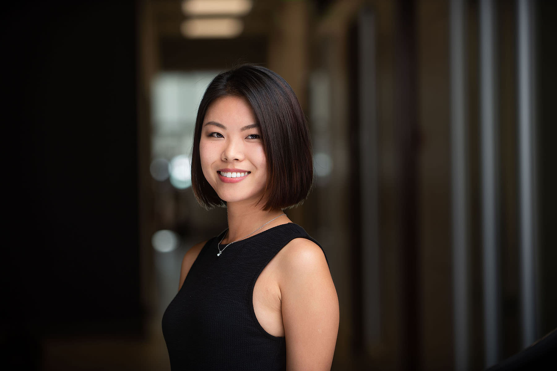 Professional woman smiling in a Denver office environment, perfect for professional headshots.